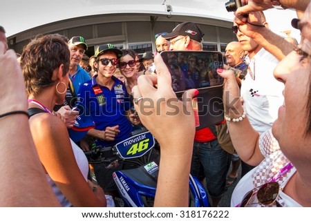 BRNO, CZ - AUGUST 14: Valentino Rossi of Yamaha Factory Racing MotoGP team poses for fans at Czech Republic Grand Prix on August 14, 2015 in Brno, Czech Republic.