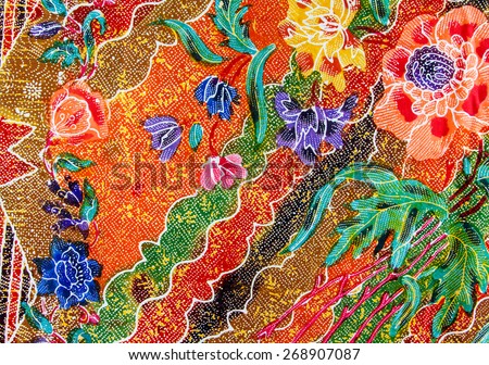 Batik design in Thailand for traditional clothes. Colorful orange tone background and flower style.