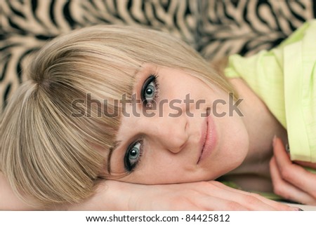 Girl\'s face lying on a sofa close up on a striped background