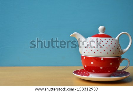 Red polka dot kettle on wooden