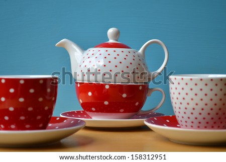 Red polka dots kettle with two cup of tea
