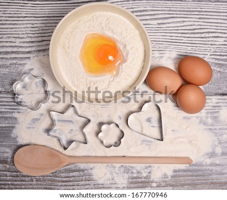 ingredients and molds for baking cookies on wooden background