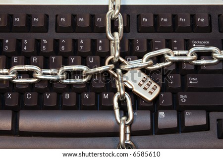 Computer Keyboard wrapped with lock and chains to prevent unwanted access, computer hacking, theft and piracy