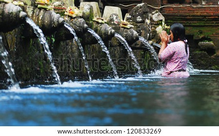 TIRTA EMPUL, INDONESIA - AUGUST 30: unidentified Woman pray and bath themselves in the sacred waters of the fountains, in Tirta Empul, Bali, Indonesia, on August 30, 2007. Fountains are in a temple