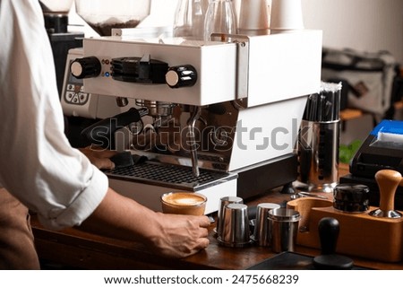 Image, Stock Photo Barista preparing a coffee at the sieve carrier machine in a café