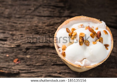 Coconut ice cream with peanuts on coconut shell.