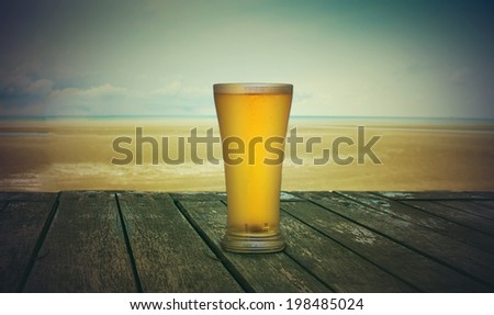 Cold beer on wood table in front the sea of Thailand