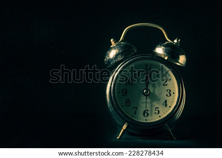 Still life with old alarm clock on dark background,paint lighting