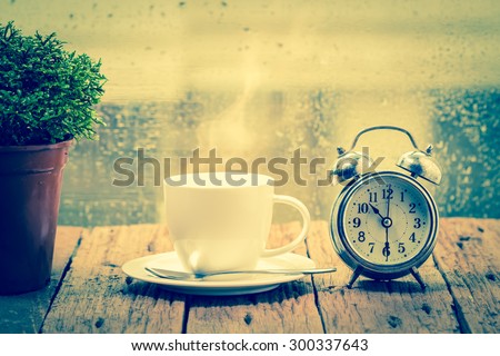 Steaming coffee cup on a rainy day window background,good time of coffee