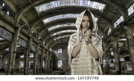 Young woman in ancient costume in old factory