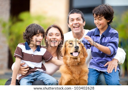 Family outdoors with a dog looking very happy