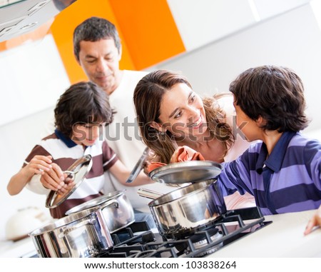 Family cooking together in the kitchen and looking happy