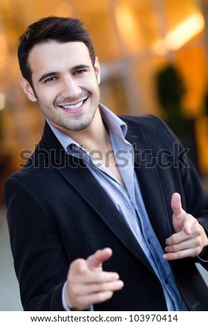 Confident man pointing at the camera and smiling