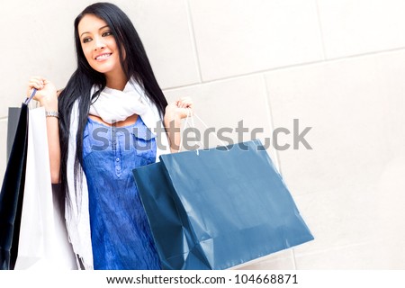 Beautiful female shopper holding bags with purchases