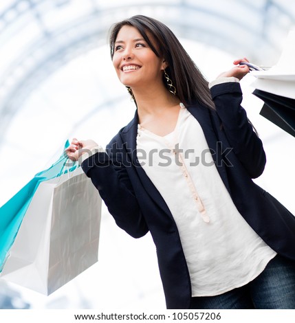 Happy woman shopping and holding bags at the mall