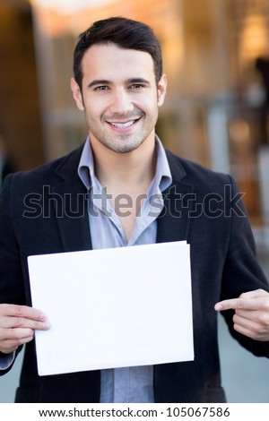 Businessman holding a white poster and smiling