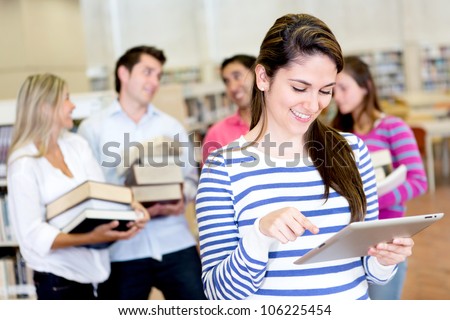 Woman with an e-book reader while friends carry books