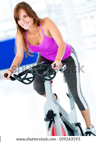 Beautiful woman at the gym on bike
