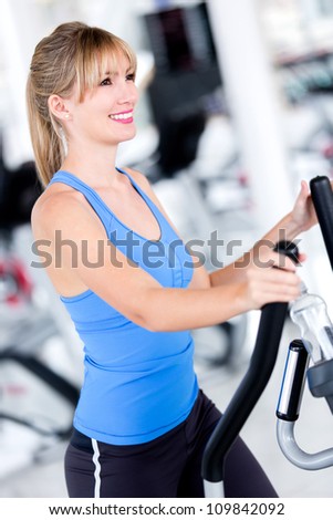 Fit woman at the gym exercising looking happy
