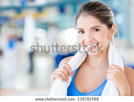 Beautiful woman at the gym holding a towel and looking happy