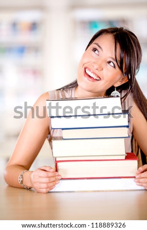 Excited female student looking up thinking at the library