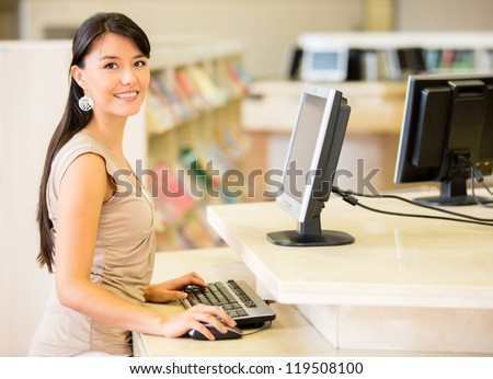 Woman at the library searching for a book on computer