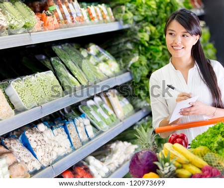 Woman at the supermarket with a shopping list