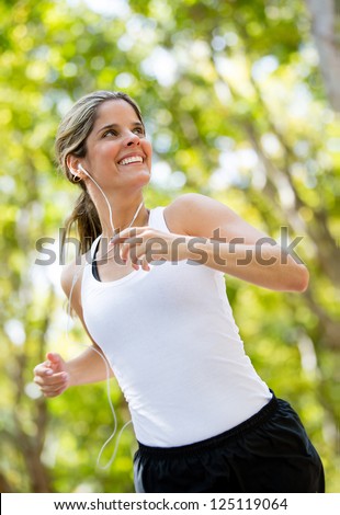 Healthy woman jogging outdoors looking very happy