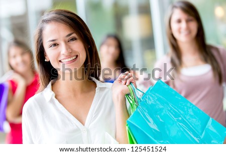 Beautiful female shopper holding bags and smiling
