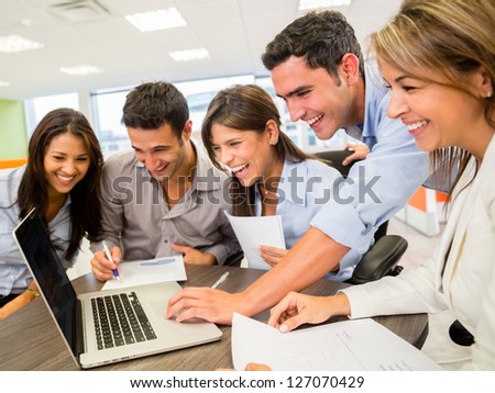 Happy group of business people looking at the computer