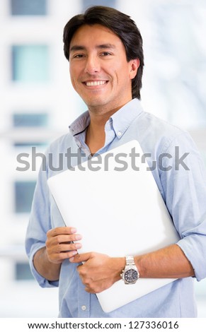 Executive man holding a laptop at the office