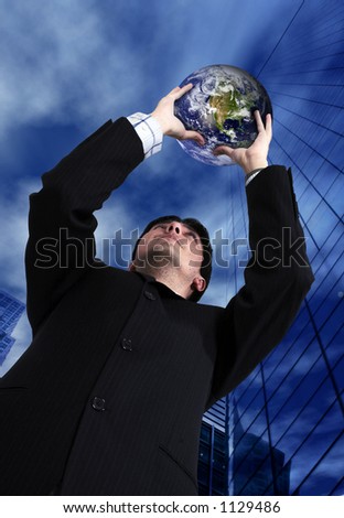 business man holding a globe up with the sky in the background