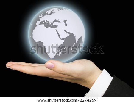 business world held by a hand over a black background - the business globe is glowing