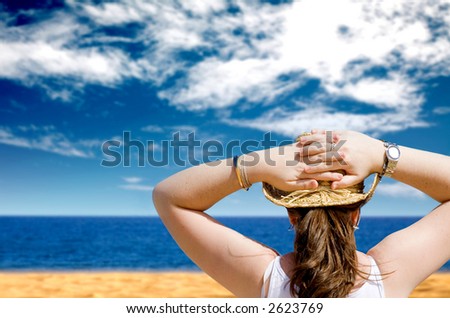 girl relaxing at the beach with her arms behind her head