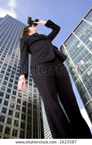 business vision - woman in corporate environment in perspective looking away with his binoculars