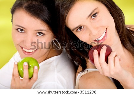 healthy girls on a fruit diet holding apples on their hands over a light green background