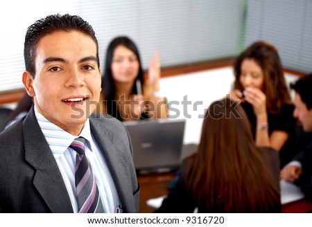 business man smiling leading a team during an office meeting