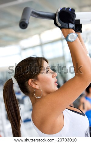young woman exercising at the gym doing some pull ups