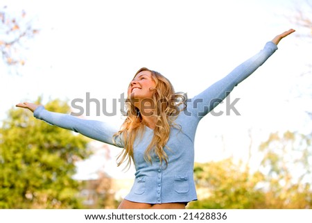 freedom woman smiling outdoors in a park with arms open