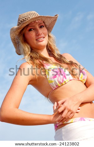 beautiful bikini woman smiling at the beach wearing a hat