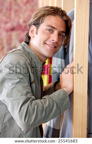 Handsome man at a clothing store smiling