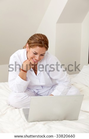 Girl in bed with a laptop computer browsing