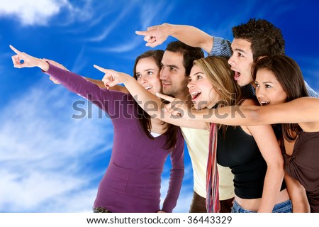 Group of friends pointing out at the sky