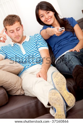 Woman with the remote control and man looking bored