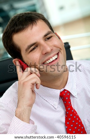 business man smiling and talking on a mobile phone in an office