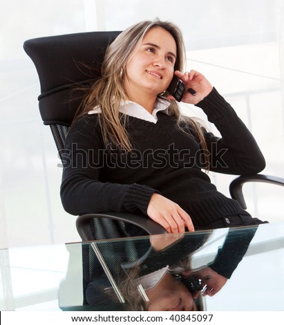 Business woman sitting on a chair talking on the phone
