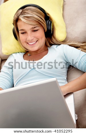 Casual student listening to music on the computer while studying at home