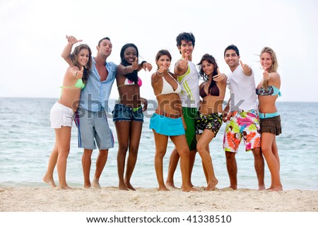 Happy group of people at the beach with thumbs up