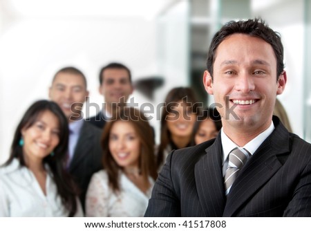 Business man smiling with his team behind him