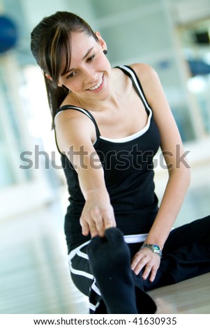 woman doing stretching exercises on the floor at the gym